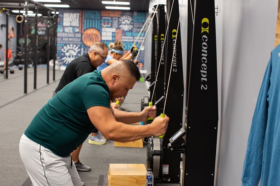 Group personal training class, members working out at Coastal Fitness using Skierg machines
